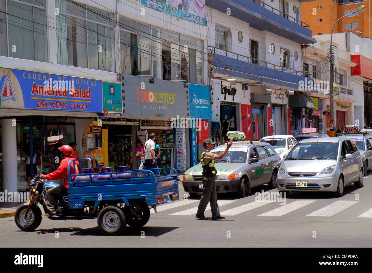 Tacna Peru,Calle San Martin,commercial district,storefront,street scene,traffic,stopped,tricycle,cart,car,Hispanic man men male adult adults,traffic,c Stock Photo