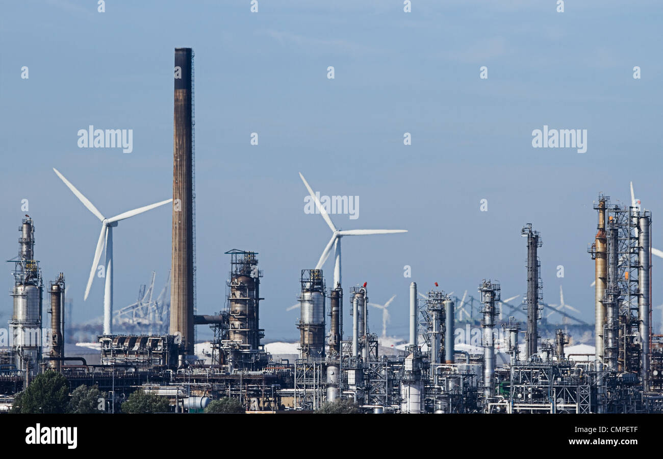 View on industrial pollution with modern windmills in background - polluting against clean energy Stock Photo