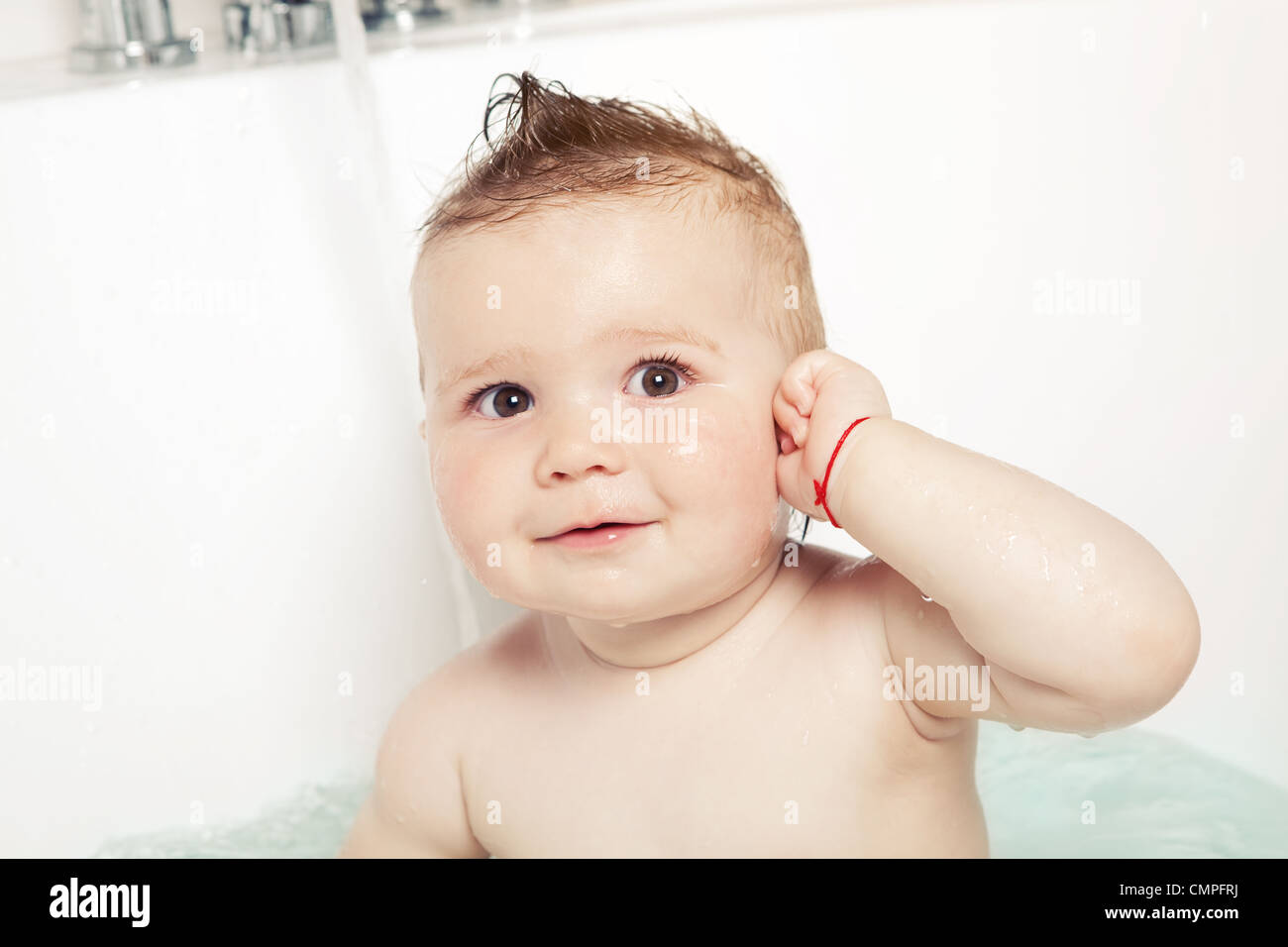 Cute baby showing "where the ear is" and smiling while taking a bath
