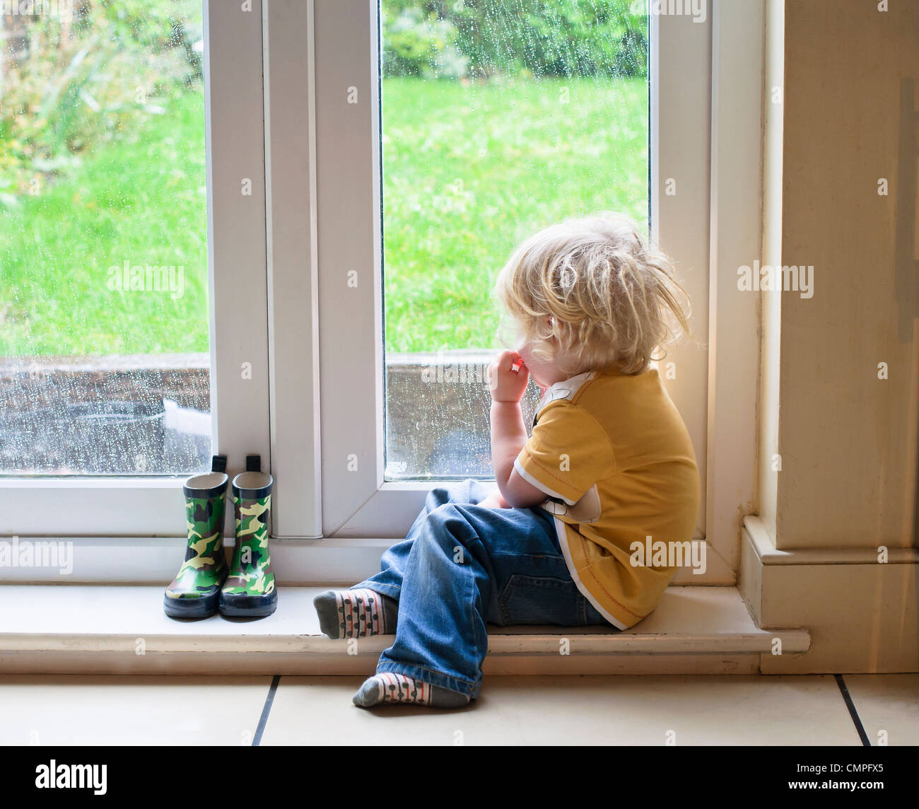 Little boy watching the rain Stock Photo Alamy