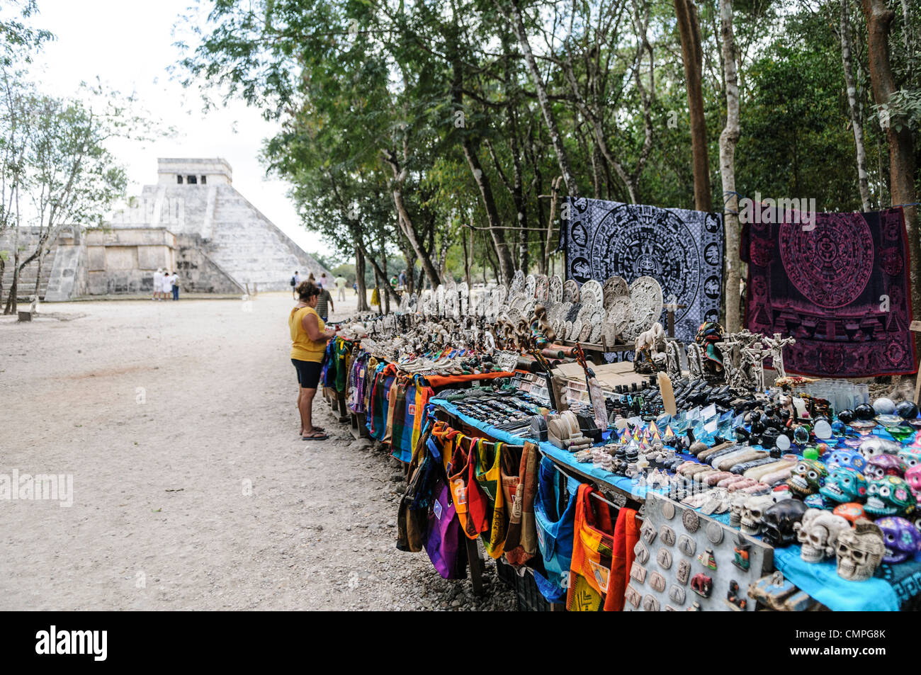 CHICHEN ITZA, Mexico - Market stalls selling local souvenirs and handicrafts to tourists visiting Chichen Itza Mayan ruins archeological site in Mexico. El Castilla is in the background. Stock Photo