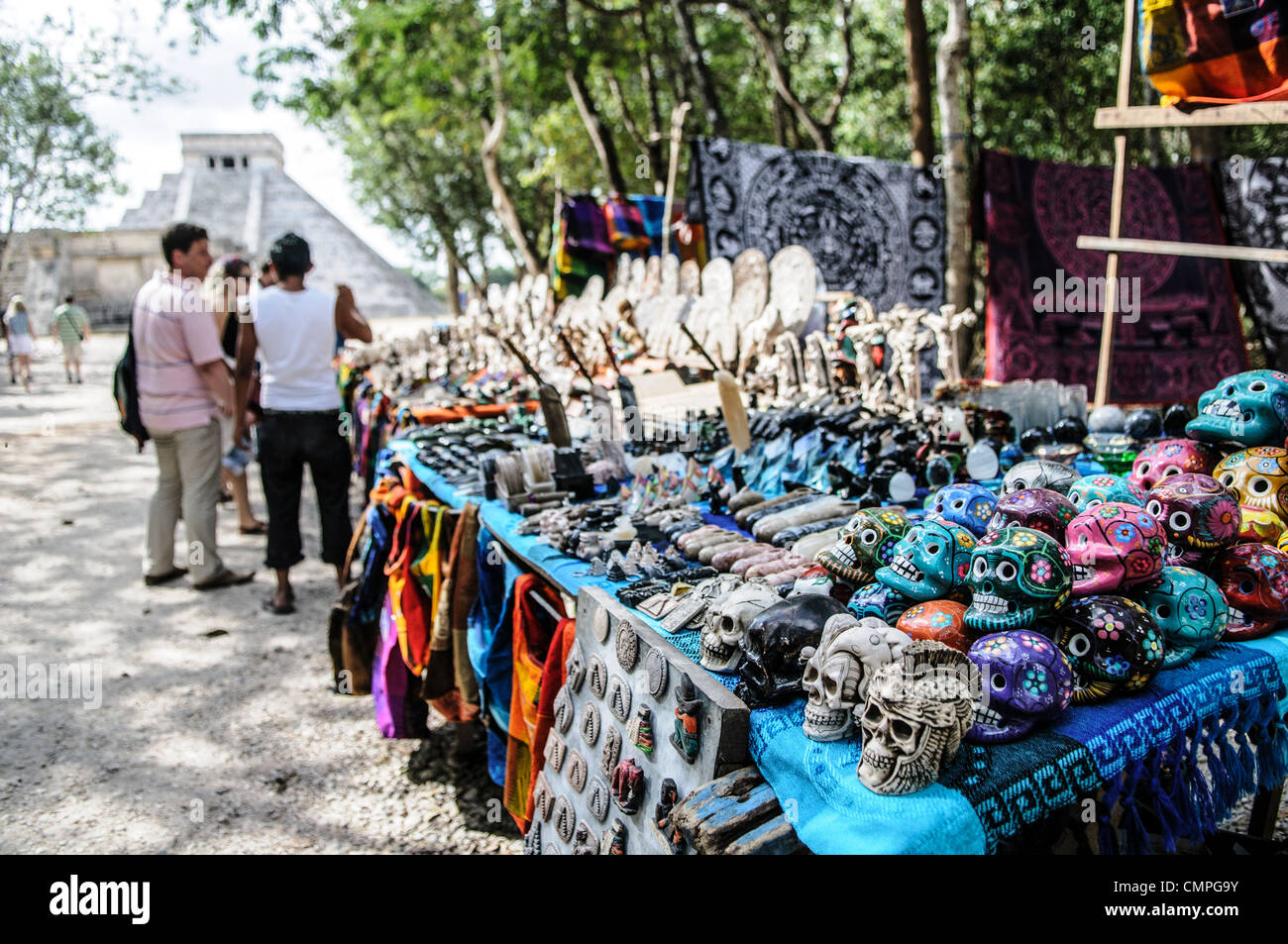 CHICHEN ITZA, Mexico - Market stalls selling local souvenirs and handicrafts to tourists visiting Chichen Itza Mayan ruins archeological site in Mexico, with El Castillo in the background. Stock Photo