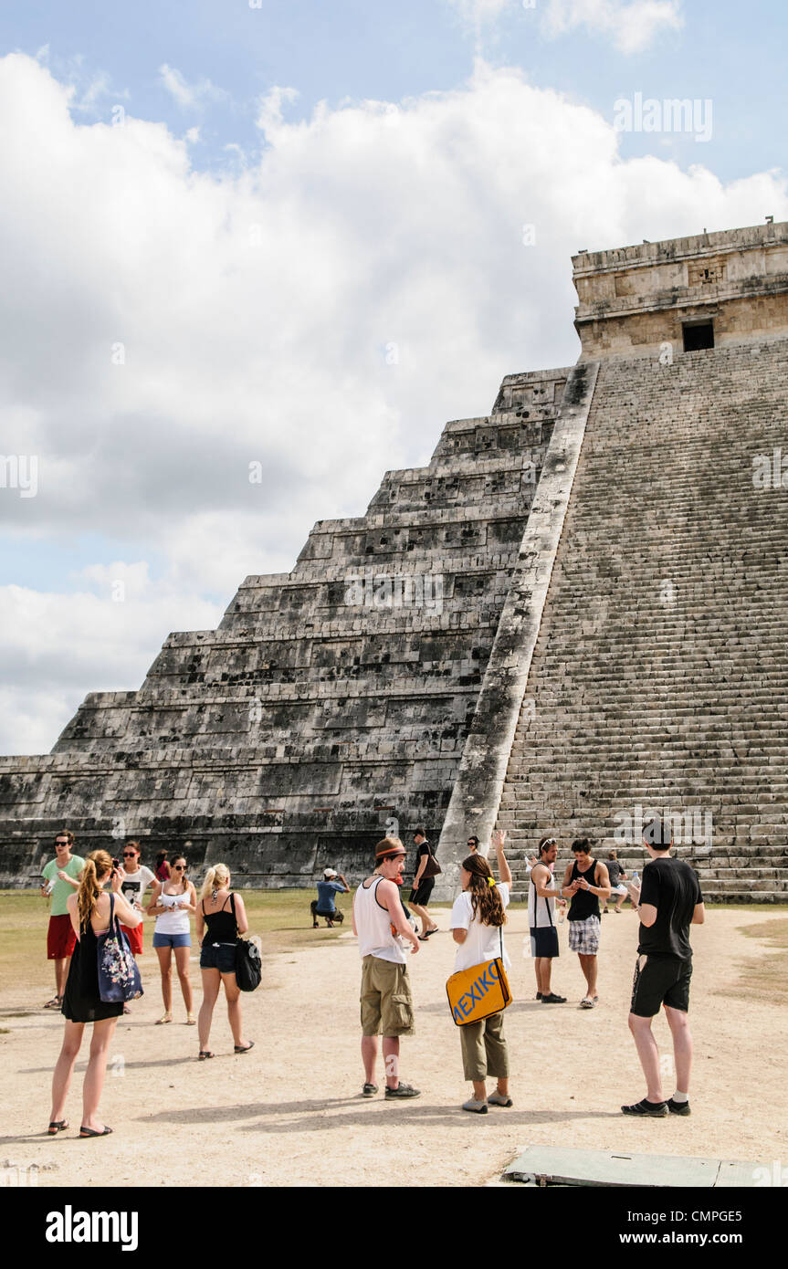 CHICHEN ITZA, Mexico - A group of tourists stand in front of the steps of the Temple of Kukulkan (El Castillo) at Chichen Itza Archeological Zone, ruins of a major Maya civilization city in the heart of Mexico's Yucatan Peninsula. Stock Photo