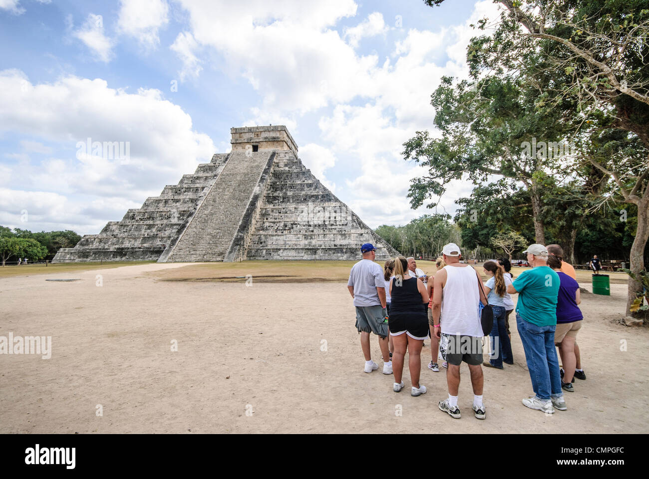 CHICHEN ITZA, Mexico - Temple of Kukulkan (El Castillo) at Chichen Itza Archeological Zone, ruins of a major Maya civilization city in the heart of Mexico's Yucatan Peninsula. A group of tourists stands to the right of frame. Stock Photo