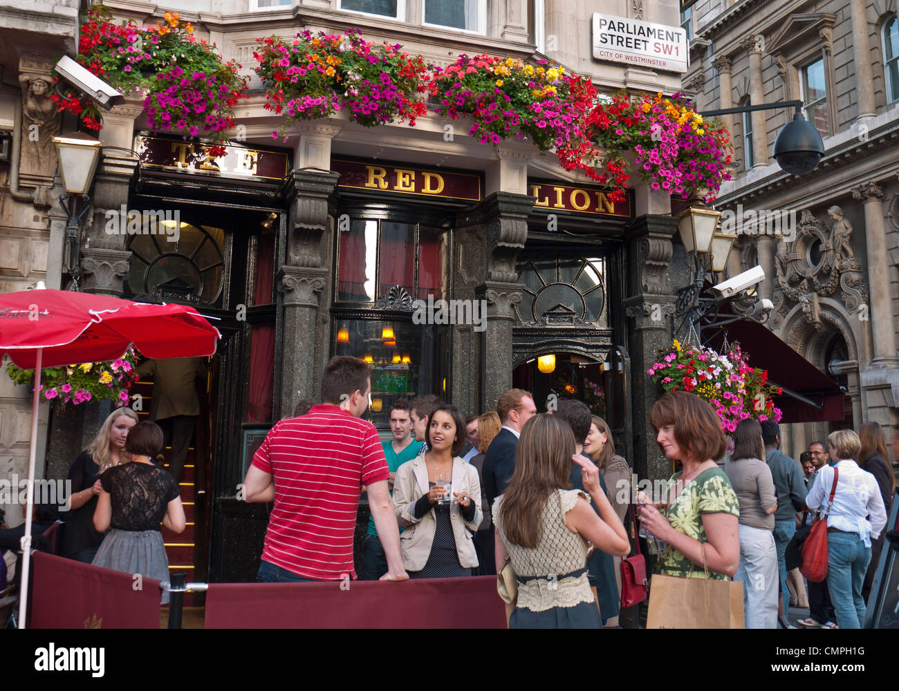 DRINKING PAVEMENT STREET OUTDOORS BUSY PUB people with drinks outside the Red Lion public house Parliament Street London SW1 Stock Photo