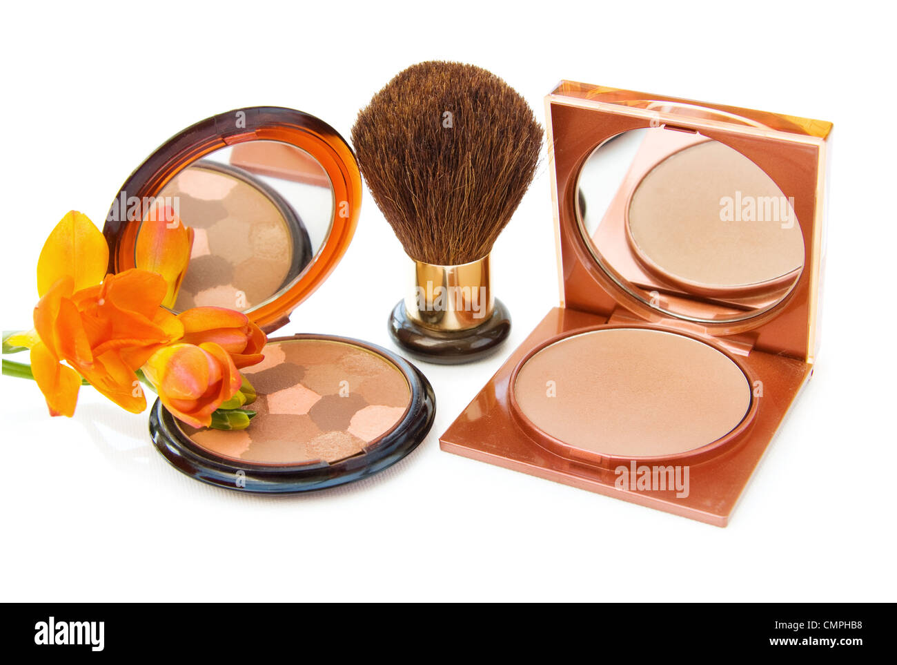Luxury makeups bronzers with brush and Freesia flower. Isolated on white background. Stock Photo