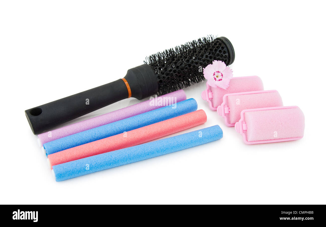 Hair dressing tools - hair brush and foam curlers with pink flower. Isolated over white background. Stock Photo