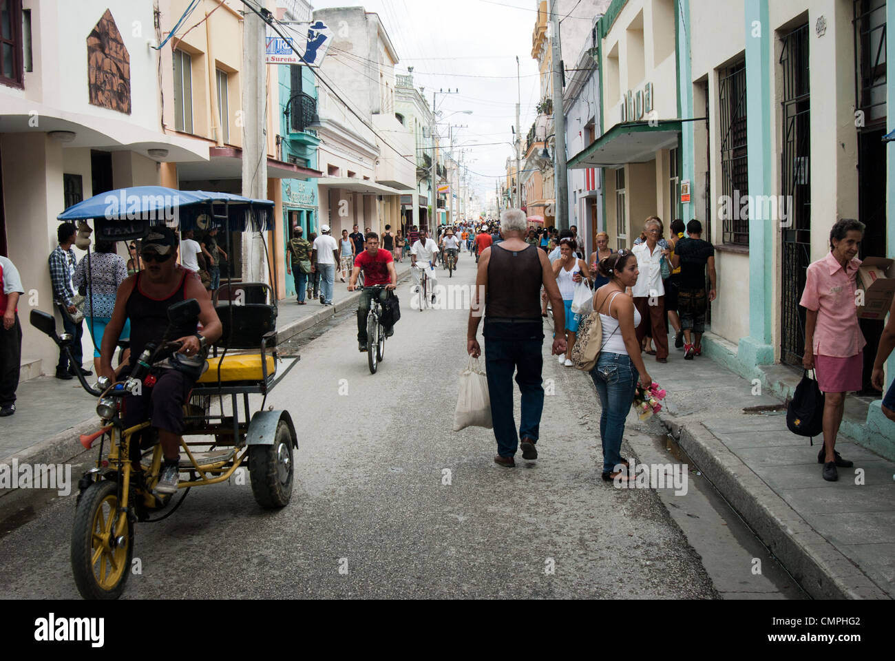 street scene, rickshaw, person on a bicycle, Calle Republica/ Republic street in Camaguey Stock Photo