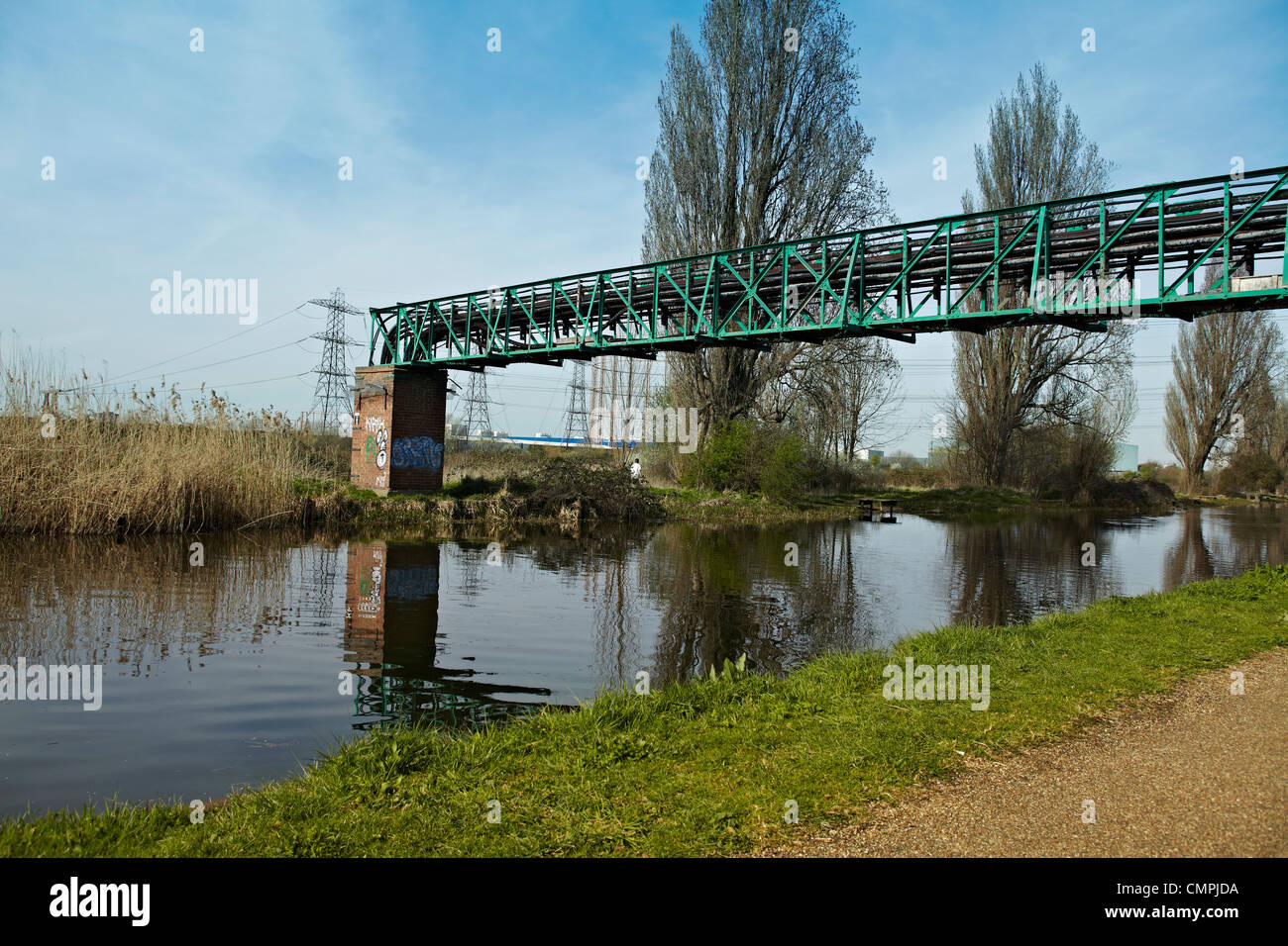 Canal scene with electricity pylons and pipe bridge on a sunny day. Stock Photo