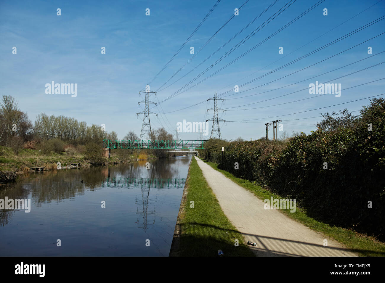 Canal scene with electricity pylons and pipe bridge on a sunny day. Stock Photo