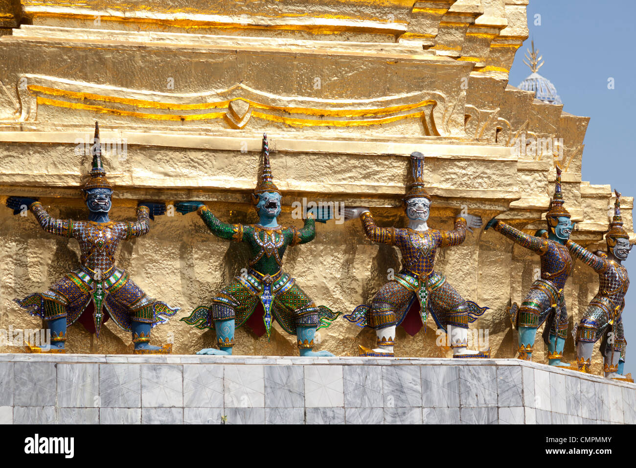 In the Wat Phra Kaew, twisted Garudas seem to support a gilded tower (Bangkok). Garudas dans l'enceinte du temple Phra Kaew. Stock Photo