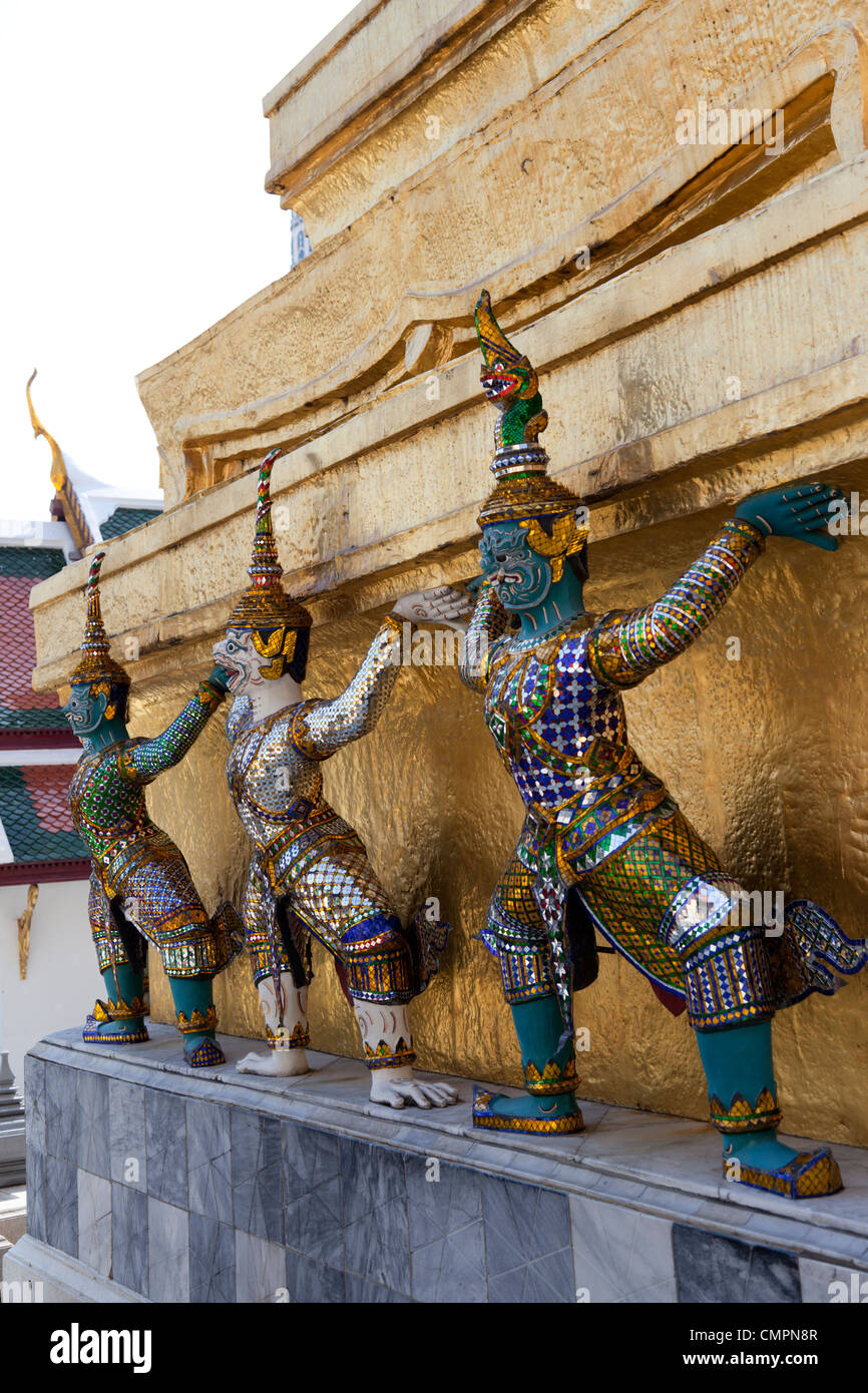 In the Wat Phra Kaew, twisted Garudas seem to support a gilded tower (Bangkok). Garudas dans l'enceinte du temple Phra Kaew. Stock Photo