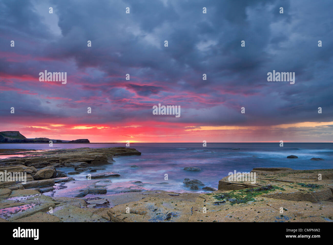 Sunset and stormy clouds at low tide in Saltwick Bay, Yorkshire, England, United Kingdom, Europe Stock Photo