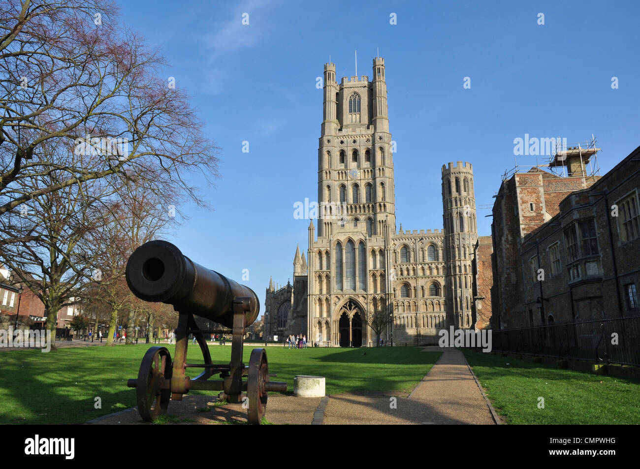 The west tower of Ely Cathedral from Palace Green with the cannon which was captured from the Russians in Sebastopol Stock Photo