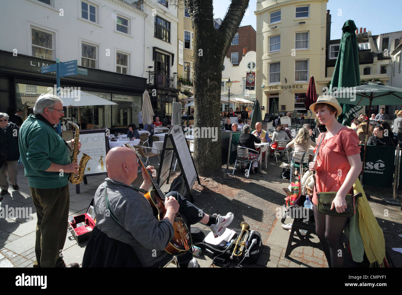 Musicians entertain people outdoors in East Street, The Lanes, Brighton town centre. Stock Photo