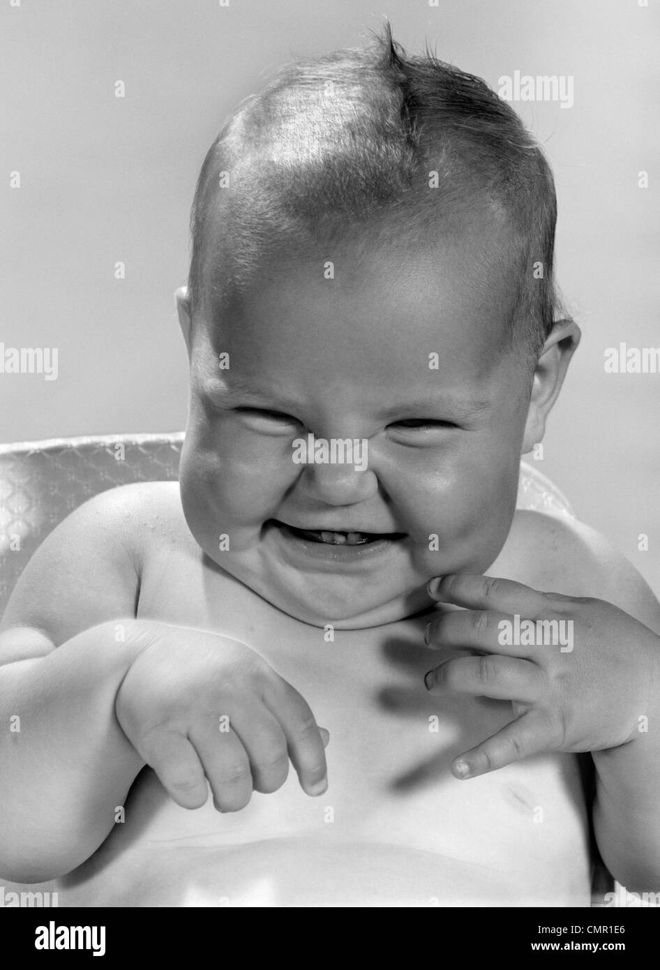 1960s PORTRAIT OF SMILING BABY INDOOR MAKING A FUNNY FACE Stock Photo