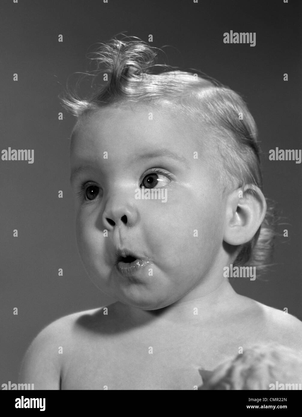 1960s HEAD SHOT OF BABY WITH SURPRISED EXPRESSION Stock Photo
