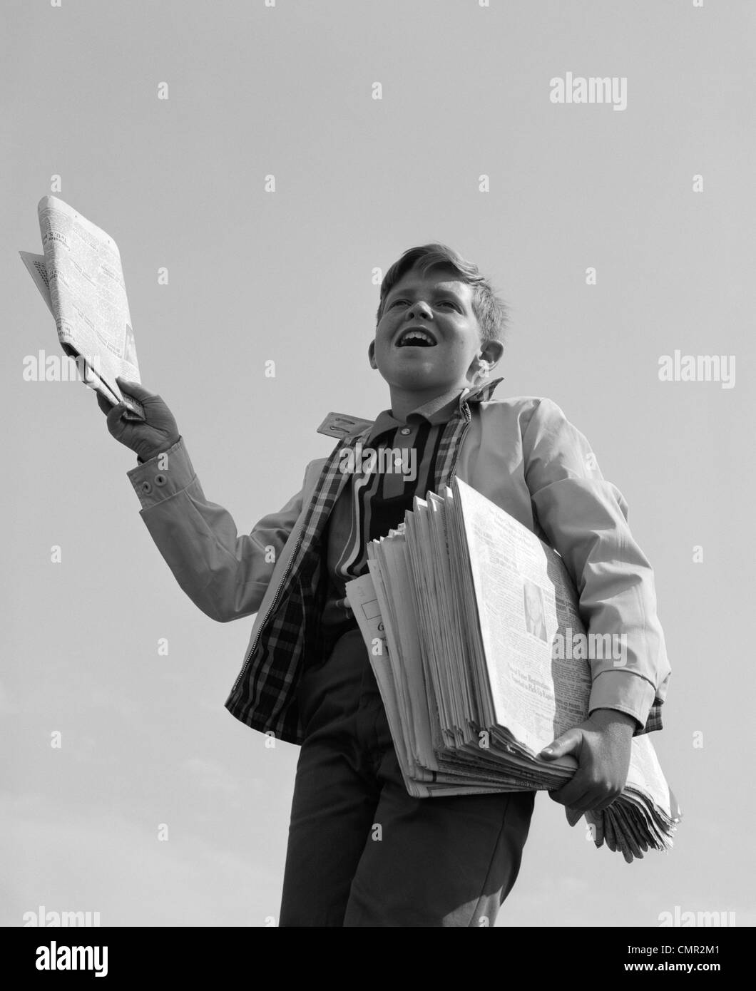 1960s PAPERBOY WITH STACK OF PAPERS UNDER ARM CALLING EXTRA! EXTRA! Stock Photo