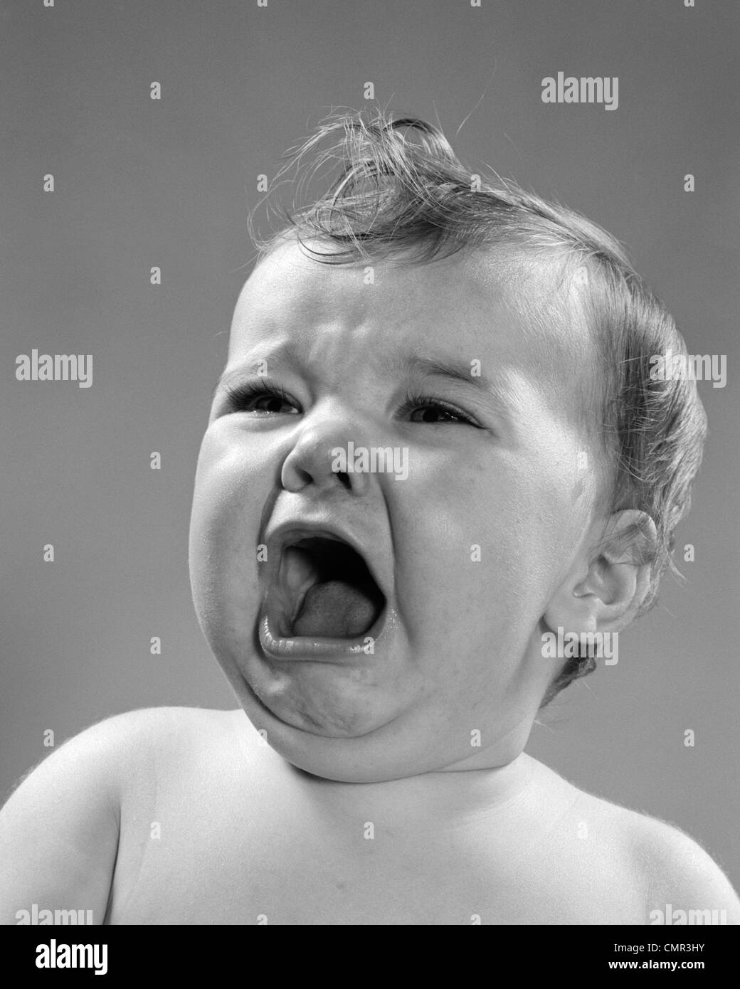 1950s CLOSE-UP OF BABY SCREAMING & CRYING WITH HEAD TURNED TO SIDE Stock Photo