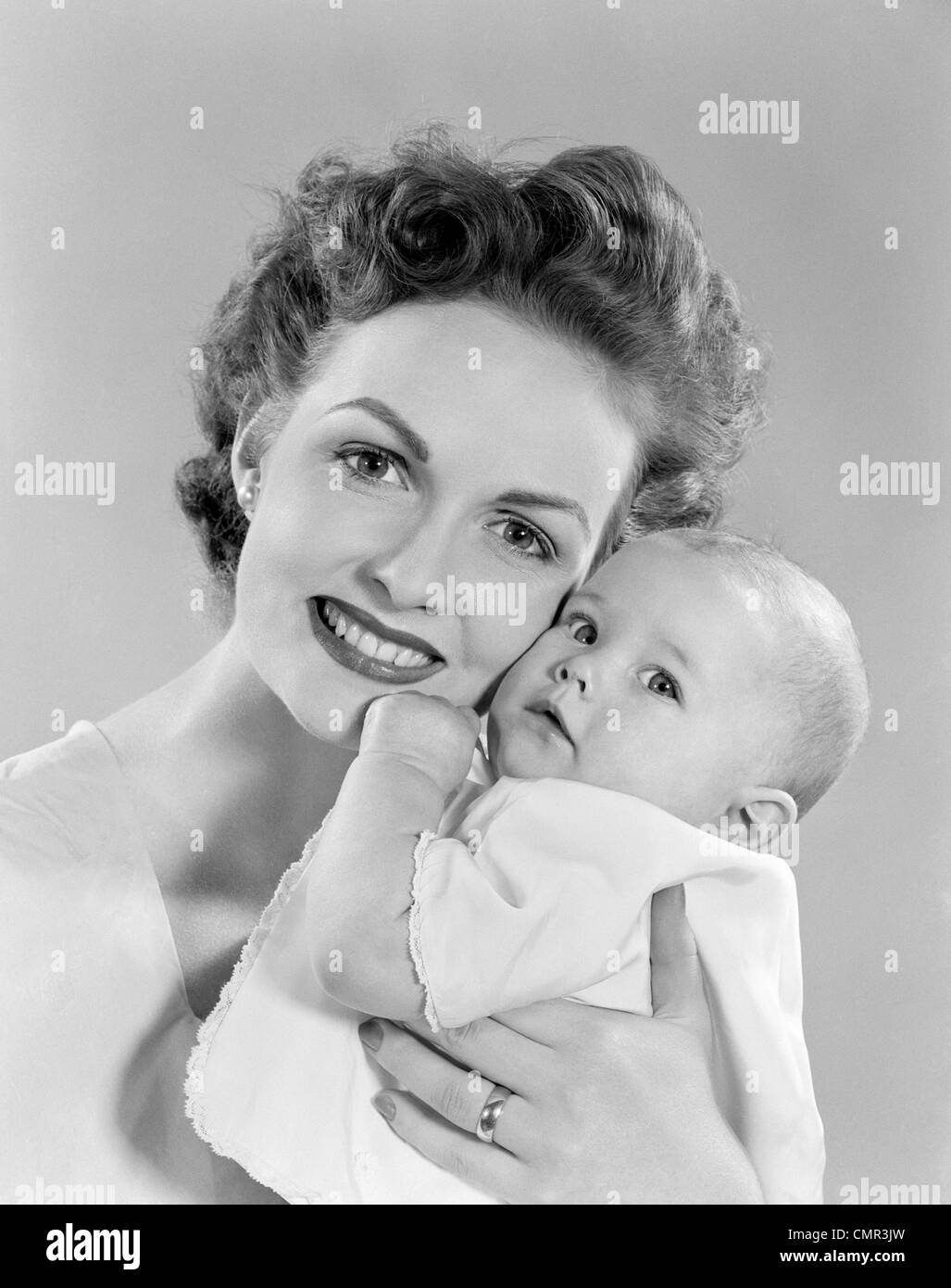 1950s PORTRAIT OF MOTHER HUGGING BABY LOOKING AT CAMERA Stock Photo