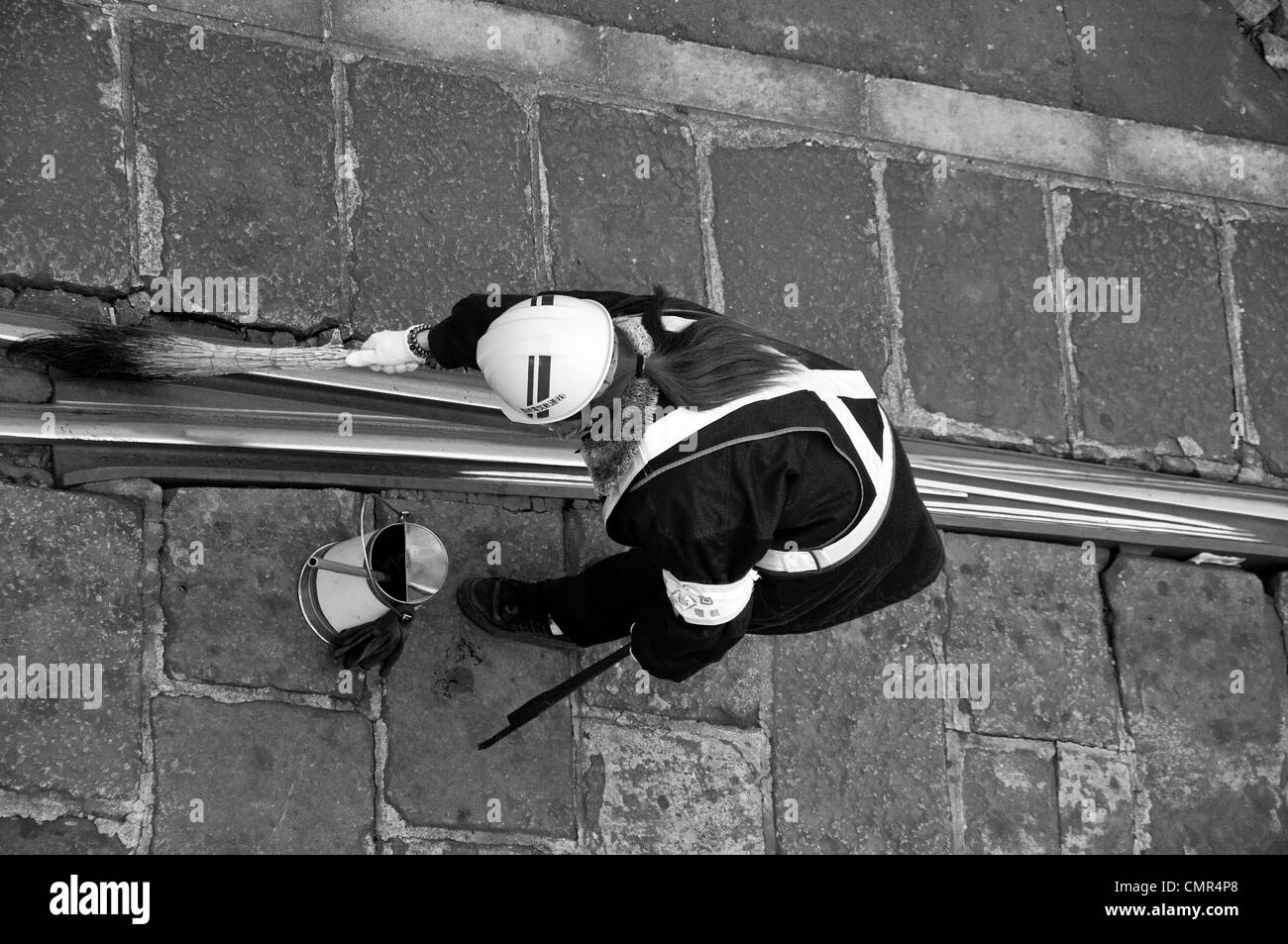 Person cleaning street car tracks in Nagasaki Japan Stock Photo