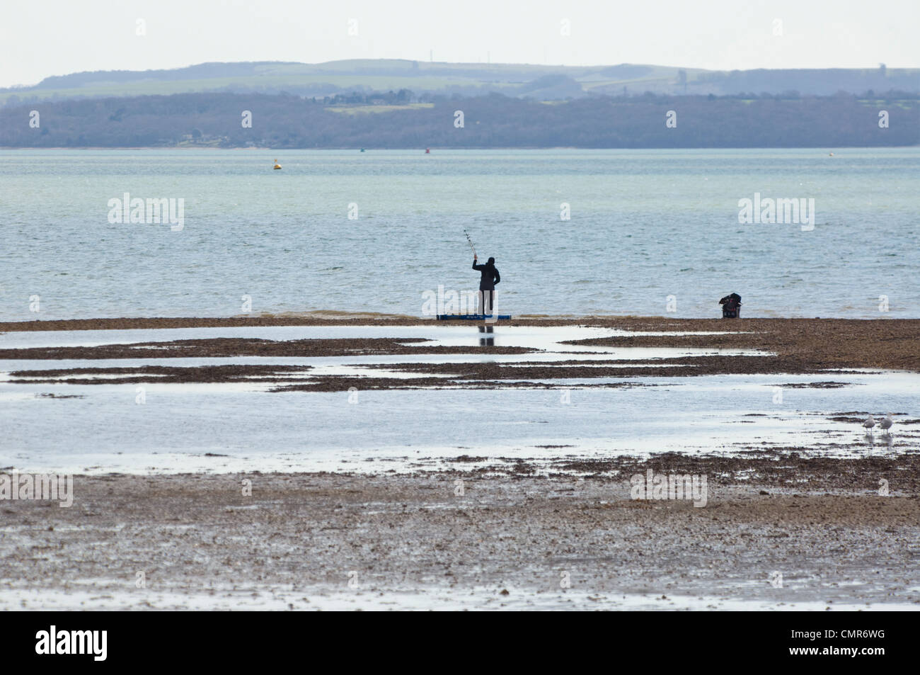 Man fishing off Meon Shore - Hampshire UK Stock Photo