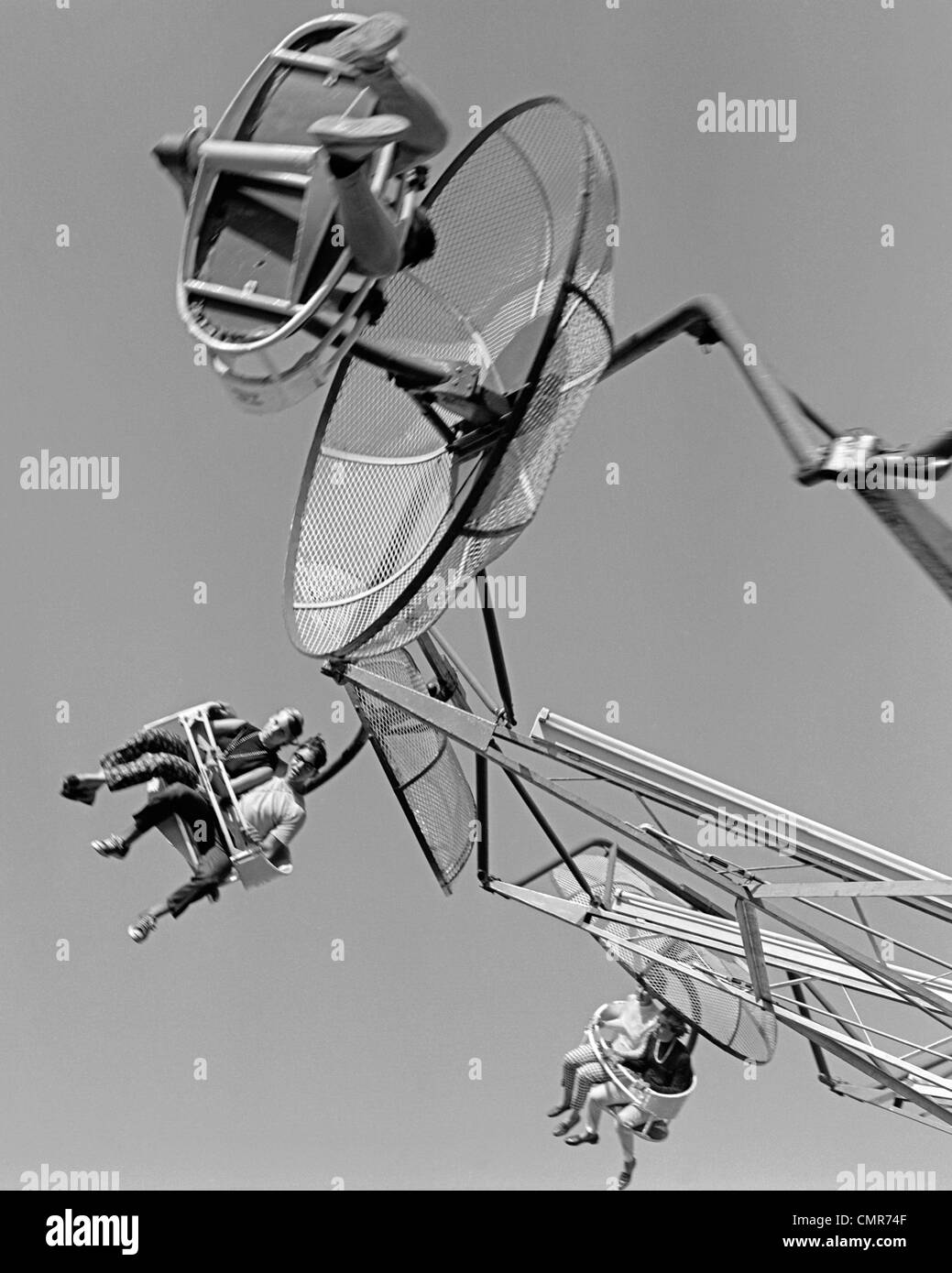 1960s SHOT OF COUPLES SEATED ON MOVING AMUSEMENT PARK RIDE Stock Photo