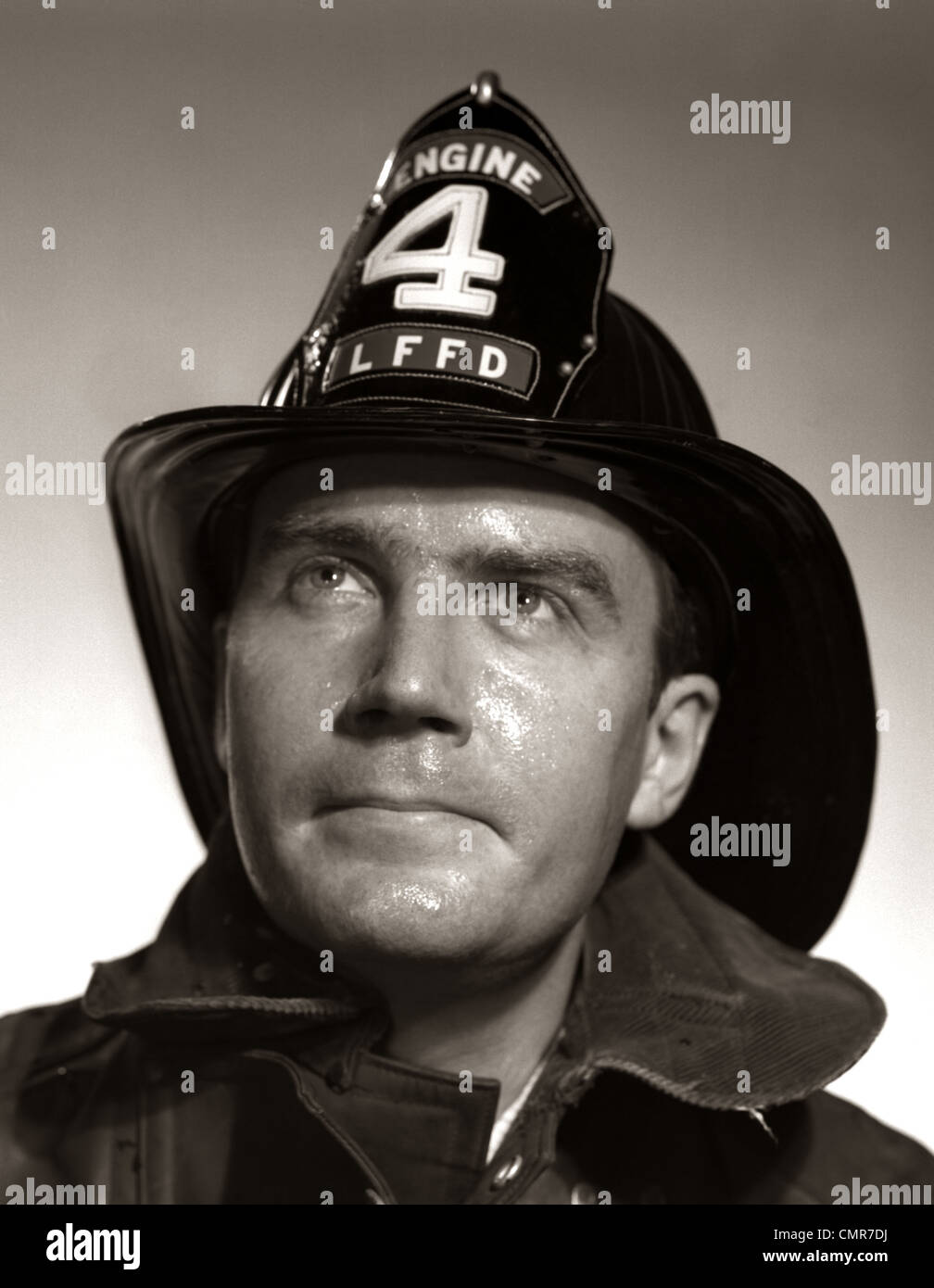 1950s PORTRAIT FIREMAN SERIOUS EXPRESSION METAL FIRE HARD HAT ENGINE 4 Stock Photo