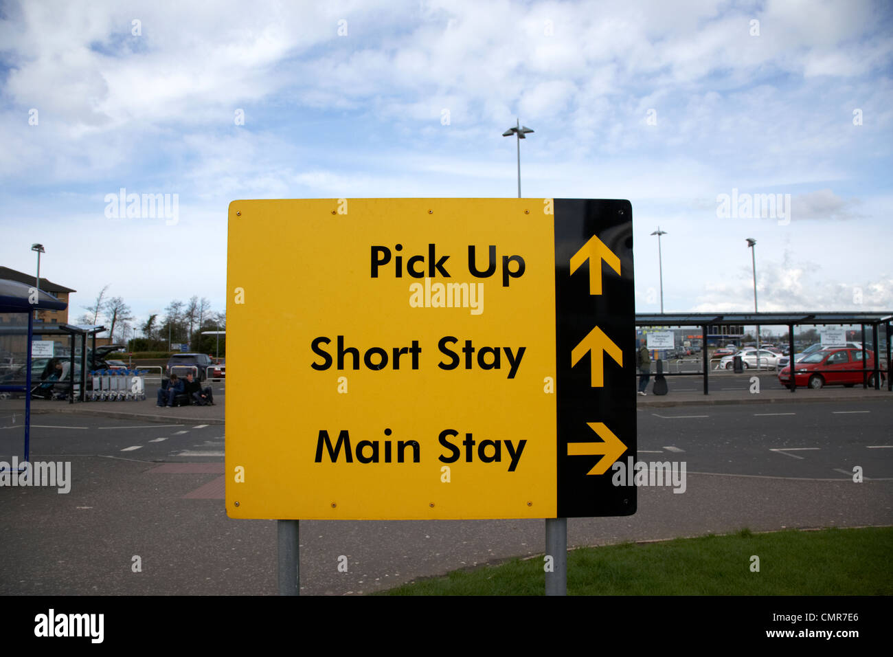 airport yellow direction signs for pick up area short and main stay car parks belfast international airport northern ireland uk. Stock Photo