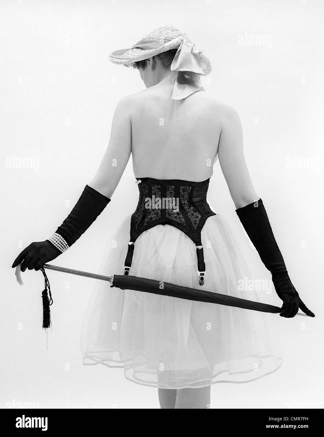 1950s BACK OF TOPLESS WOMAN WEARING HAT AND FULL LENGTH GLOVES PEARL  BRACELET GIRDLE OVER CRINOLINE SKIRT PARASOL BEHIND BACK Stock Photo - Alamy