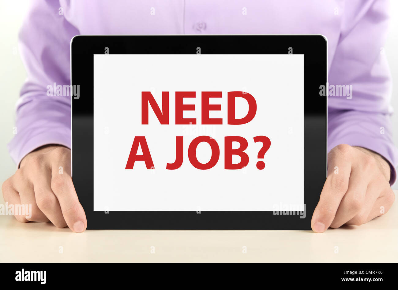 Manager holding tablet pc with 'Need a job?' text on screen. Stock Photo