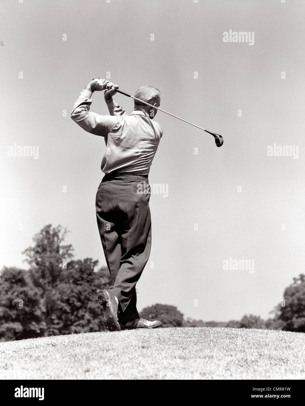 1940s 1950s MAN PLAYING GOLF TEEING OFF SWINGING DRIVER CLUB Stock Photo
