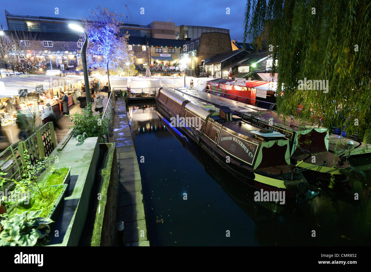 Moored narrow boats in the canal basin, Camden Lock Market, London at night. Stock Photo