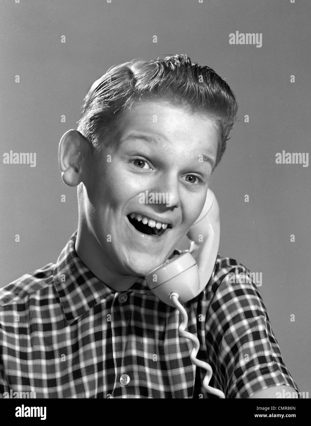1960s BOY ON TELEPHONE WITH EXCITED EXPRESSION Stock Photo