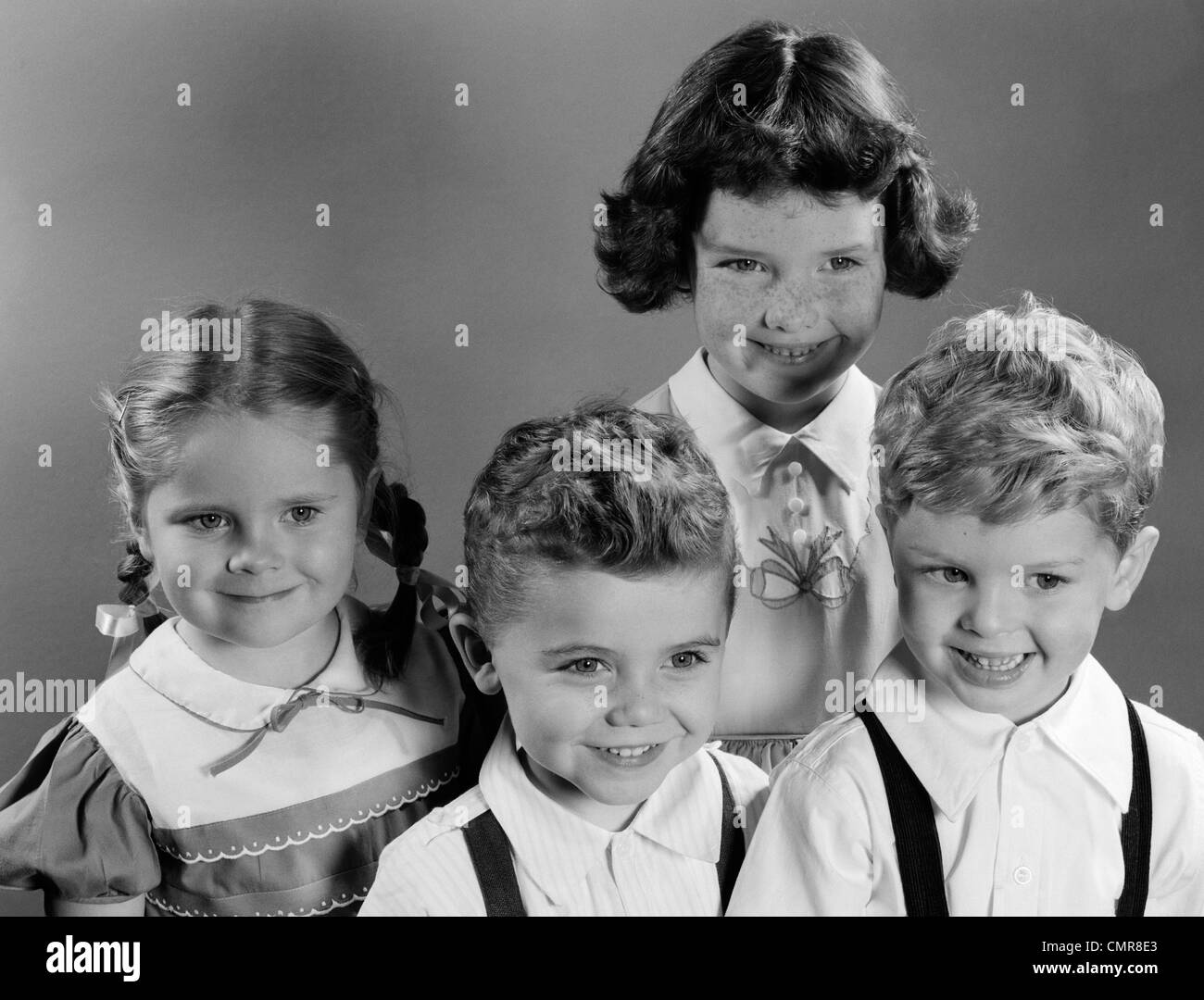 1950s PORTRAIT OF FOUR SMILING CHILDREN TWO BOYS AND TWO GIRLS Stock Photo