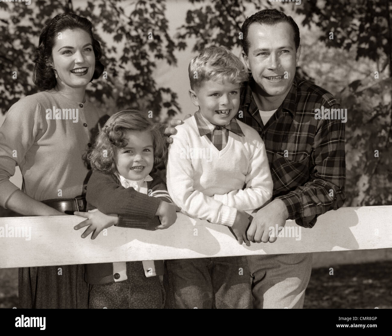 1950s FAMILY OUTSIDE SMILING MOTHER FATHER SON DAUGHTER Stock Photo