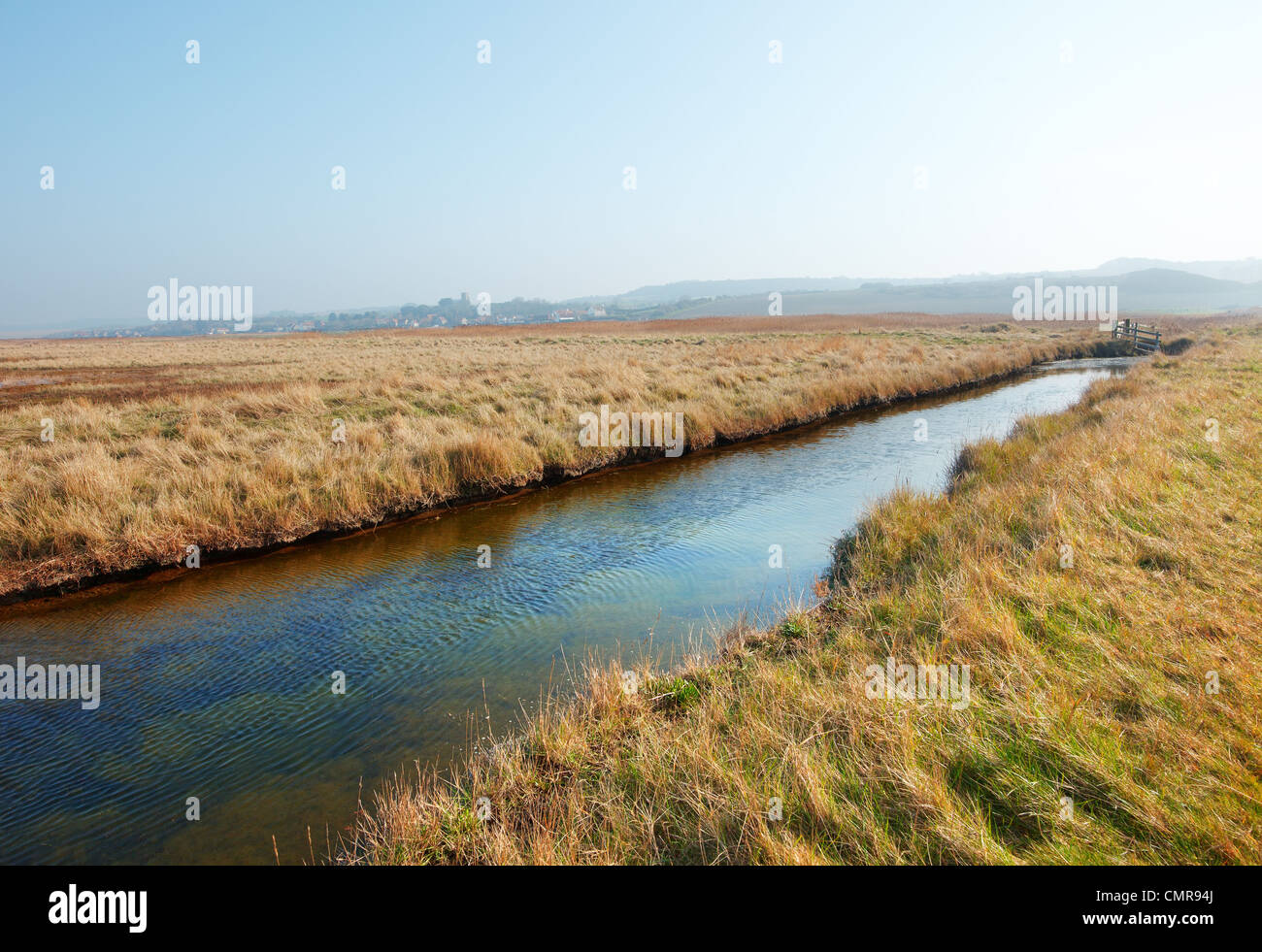 Marshland and the proctected wild life area with the town of Salthouse in the distance 'North Norfolk' UK Stock Photo