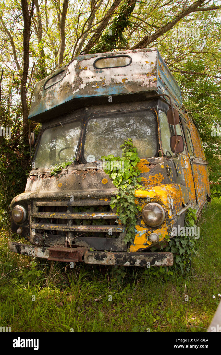 old derelict commer caravanette / motorhome covered in lichen and ivy. Stock Photo