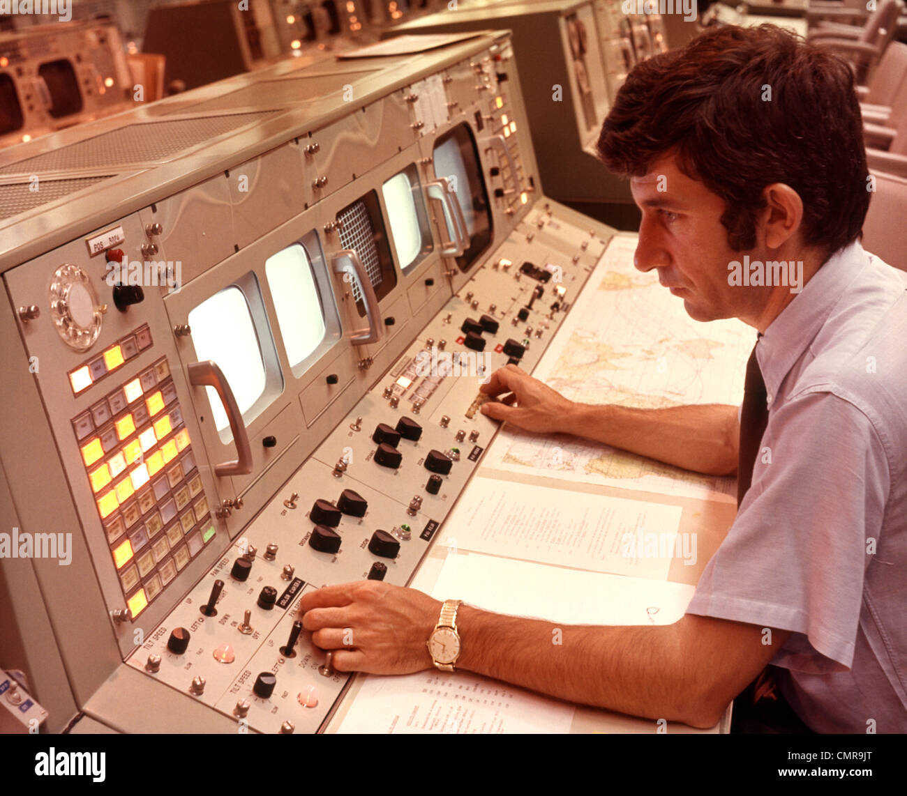 1970s MAN SITTING AT CONTROL PANEL OF NASA MISSION CONTROL HOUSTON ...