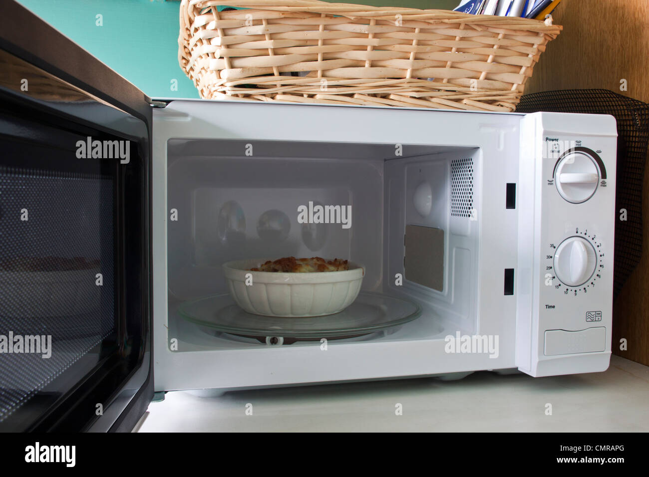 corned beef hash with cheese in microwave oven. Stock Photo