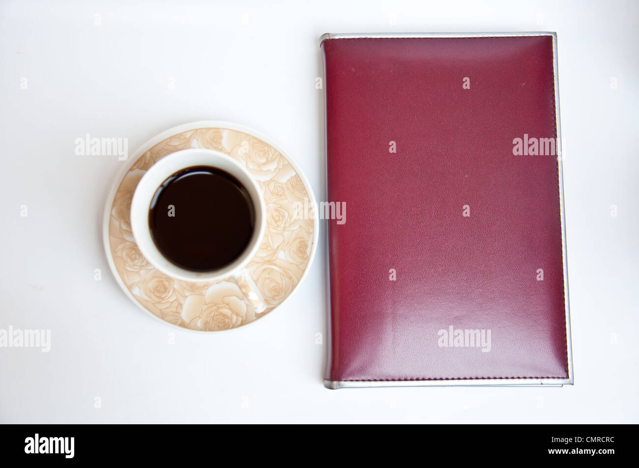 Brown notebook and black coffee on white background Stock Photo