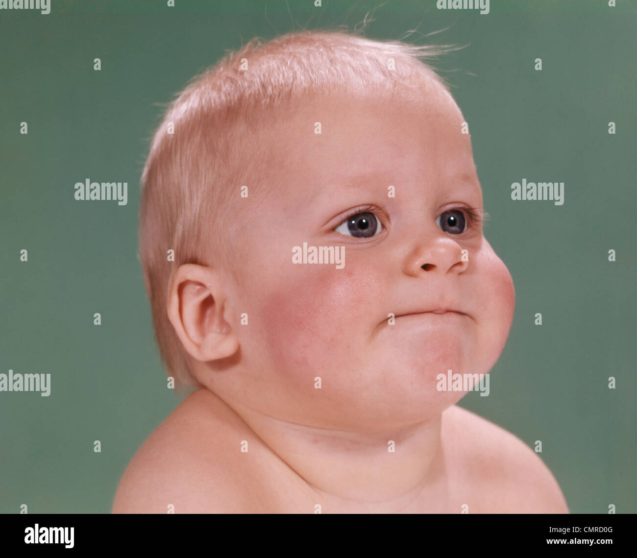 1960s PORTRAIT OF BLOND BABY CHUBBY CHEEKS WITH FUNNY FACE EXPRESSION Stock Photo
