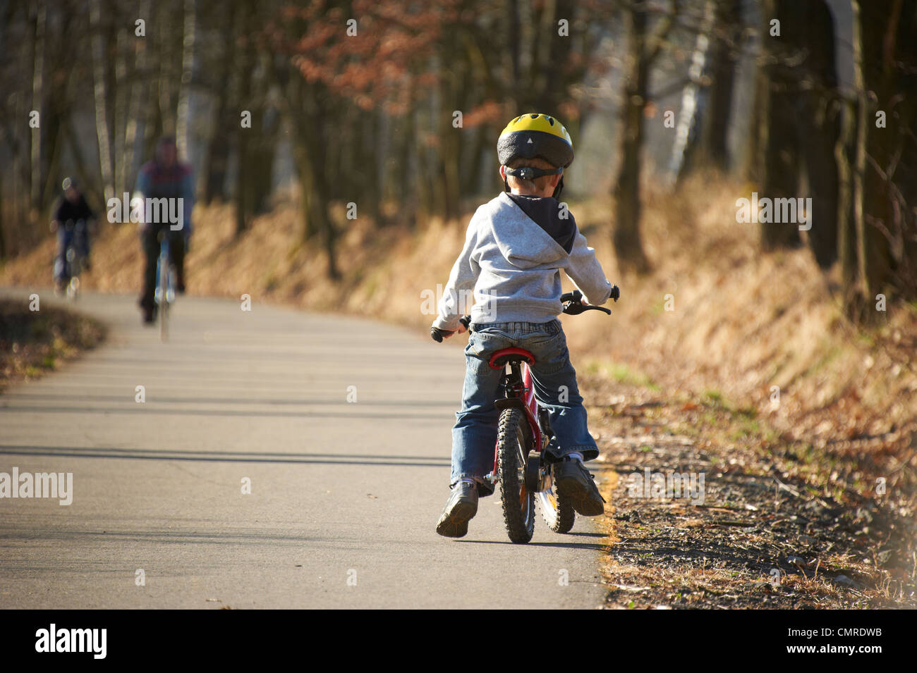 Child blond boy 5 years old riding bicycle with safety helmet in