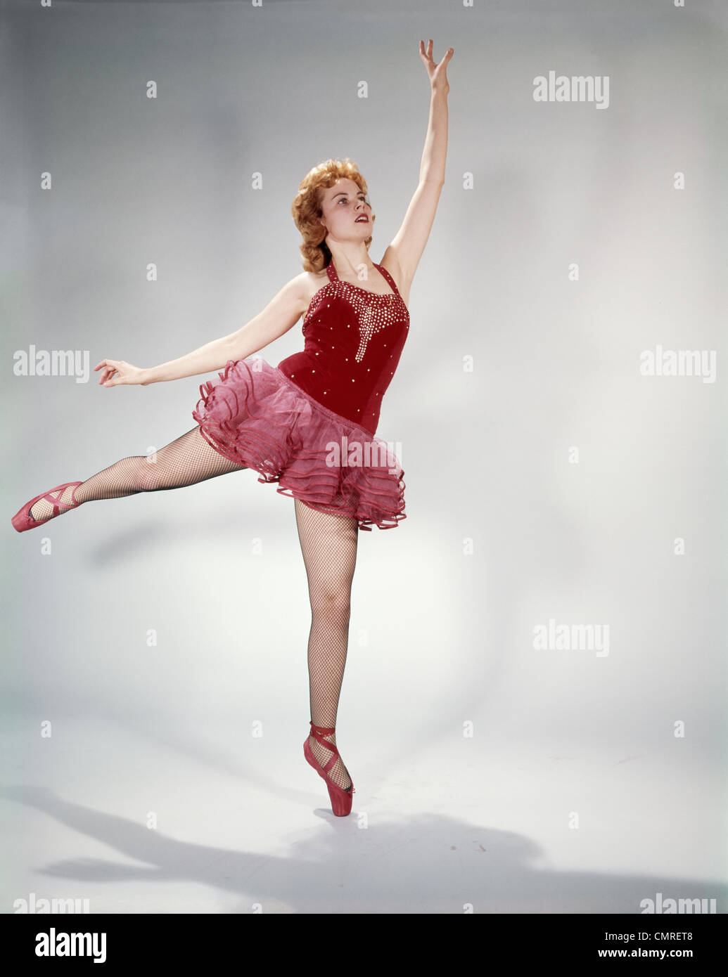 https://c8.alamy.com/comp/CMRET8/1960s-awkward-teen-girl-red-velvet-costume-pink-net-tutu-attempting-CMRET8.jpg