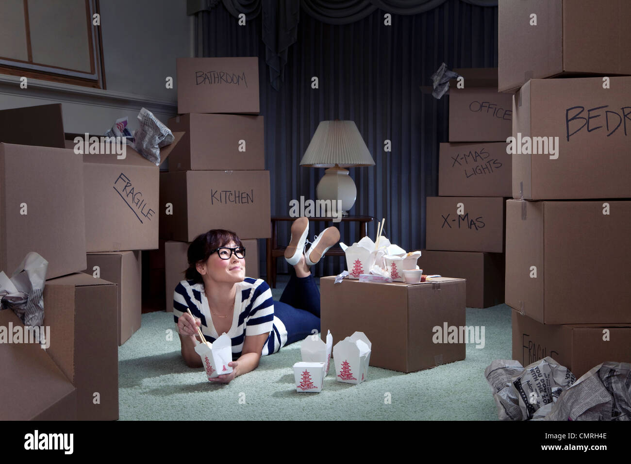 Korean woman eating take-out in new home Stock Photo