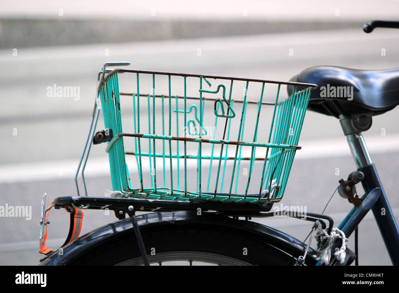 Close up of a green basket on the back of a city bike in the street Stock Photo
