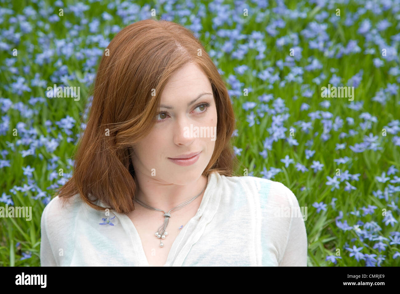 Redhaired young woman in a field of blue flowers, Whitby, Ontario