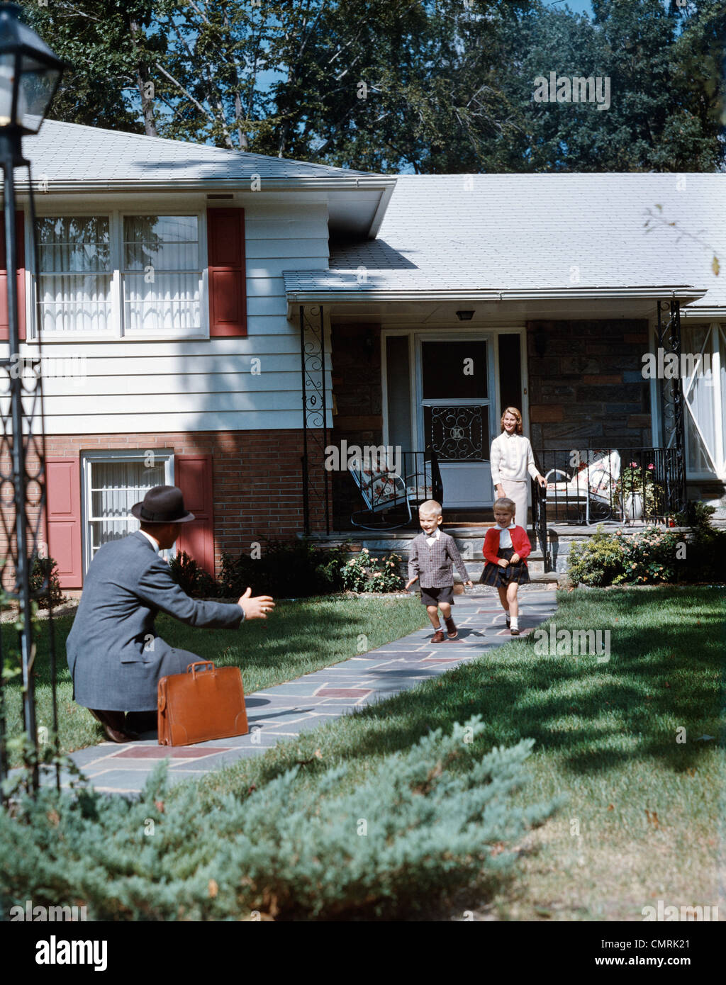 1950s FATHER COMING HOME KNEELING ARMS EXTENDED BOY GIRL RUNNING TO ...