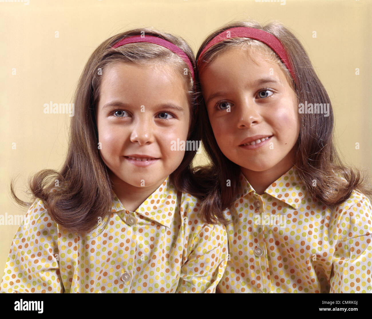1970 1970s TWINS SISTERS SMILE POLKA DOT Stock Photo