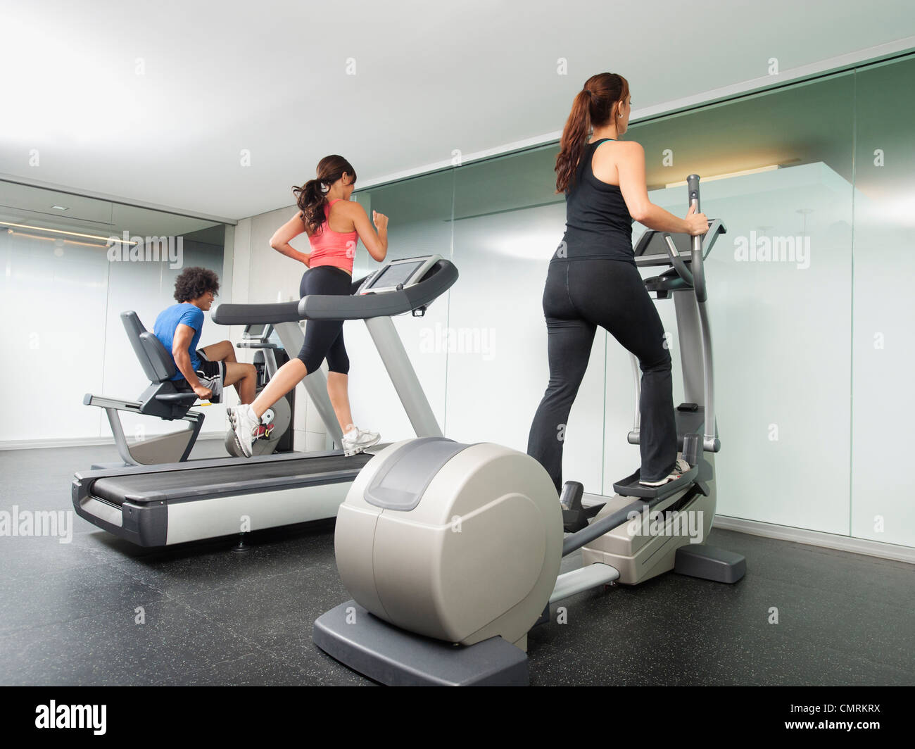 People using gym exercise equipment Stock Photo